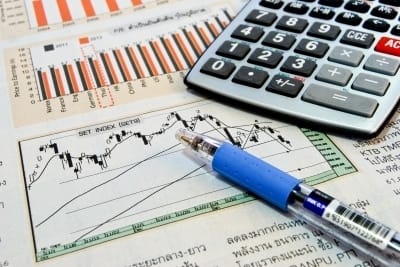 Investing confidence: calculator, pen and charts used to seek opportunity in market dip.